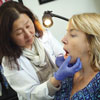 Dr. Jean Kim examining a female patient's gums