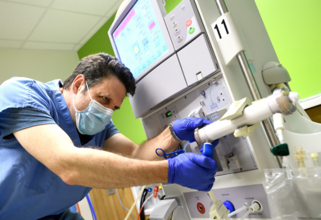 Derek Fine readies a conventional dialysis machine 