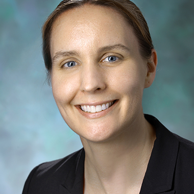 Breast surgeon Melissa Camp in a formal portrait wearing a black jacket and purple blouse.