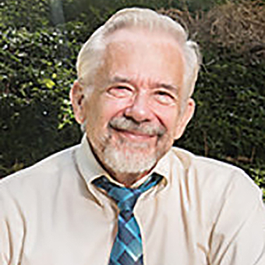 head shot of Bill Richards, smiling, outdoors, with a shirt and loosened tie