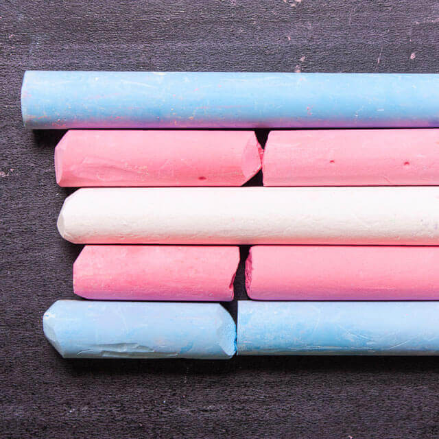 blue, pink, and white chalk arranged in the fashion of the transgender pride flag