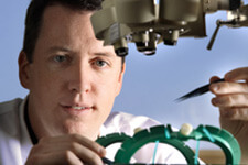 طبيب القلب جيمس بلاك يستخدم مجهرًا ومعدات أخرى.