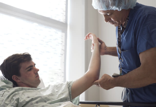doctor examining a patient's elbow before surgery