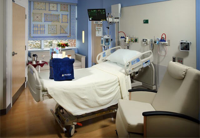 a patient room with a tote bag and fleece blanket on the bed