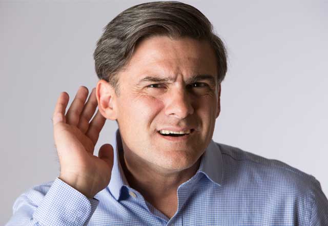man holding his hand to his ear trying to hear