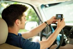caucasian boy text messaging while driving