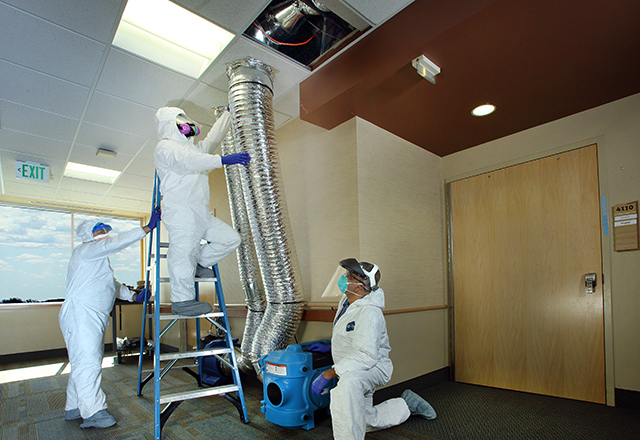 Painter Francisco Ruiz Vivas, engineering mechanic Todd Heron and chief engineer Babu Varghese add ductwork and filters to create biocontainment spaces for COVID-19 patients at Howard County General Hospital.