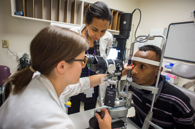 Residents at the Wilmer Eye Institute observe a patient with slit lamp