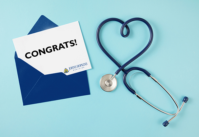 An image of an open envelope with a congratulatory message; next to it is a stethoscope in the shape of a heart.