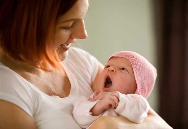 Mother looks at yawning baby