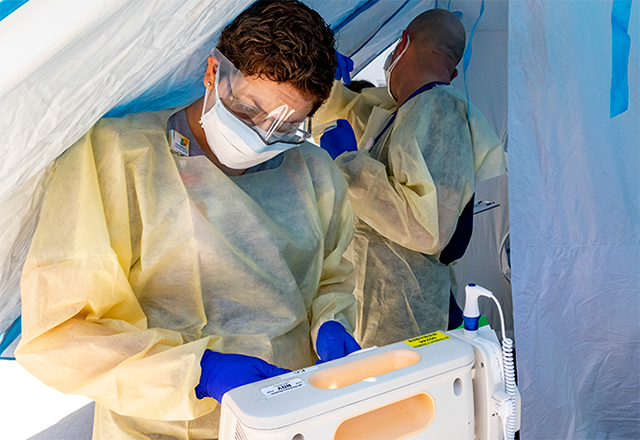 Hopkins staff members in protective equipment prepare a coronavirus test.