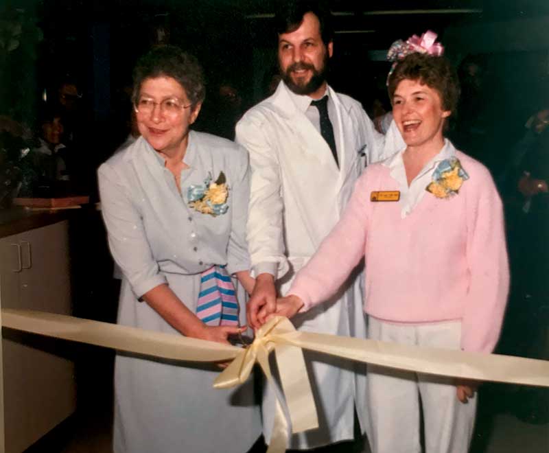 Three NCCU team members cutting a ribbon at the opening event