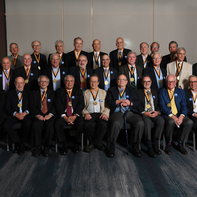 Members of the 50th reunion class (1969) gather for a photo with their commemorative medallions.