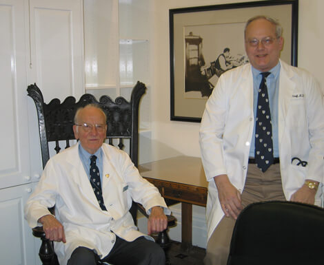 Firm founder Victor McKusick, left, with Steve Achuff, in the Osler Textbook Room.