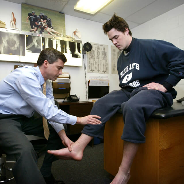 Dr. Cosgarea examining a patient's ankle