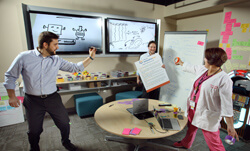 HARD FUN: Joe Sigrin, left, and Nick Dawson of the Innovation Hub loosen up their imaginations with help from Sibley nurse Silvia Ochs. The team often uses techniques from improvisational comedy in brainstorming.
