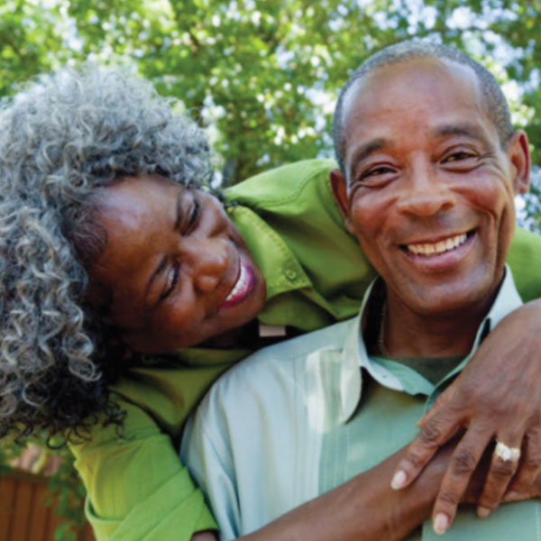 Older black woman embracing an older black man