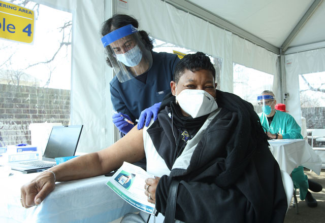 A Johns Hopkins employee administers the COVID-19 vaccine to a community member.