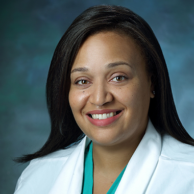Gynecological surgeon Khara Simpson, in a formal portrait, wearing a white lab coat and turquoise blouse