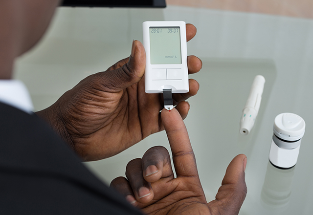 A man uses a glucose monitor.