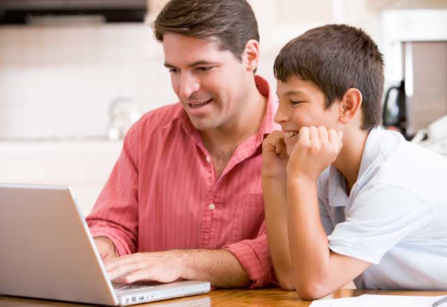father and son using a laptop