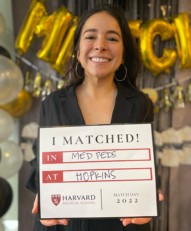 a student holding up a sign that she matched with the program