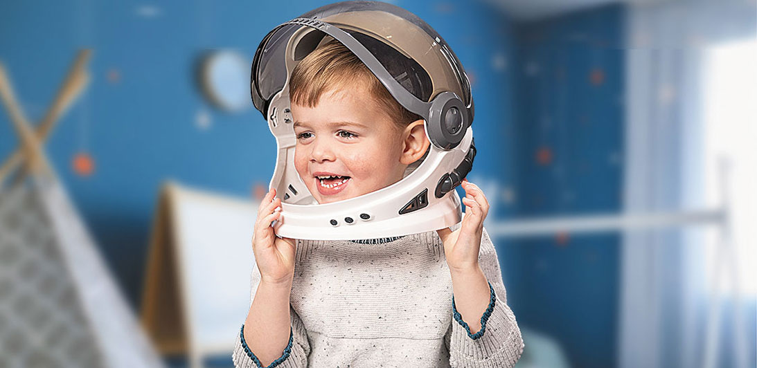 A young child playing in an astronaut helmet