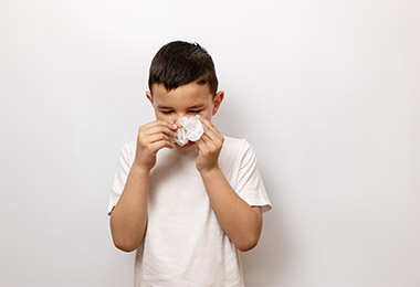 Child blowing nose.